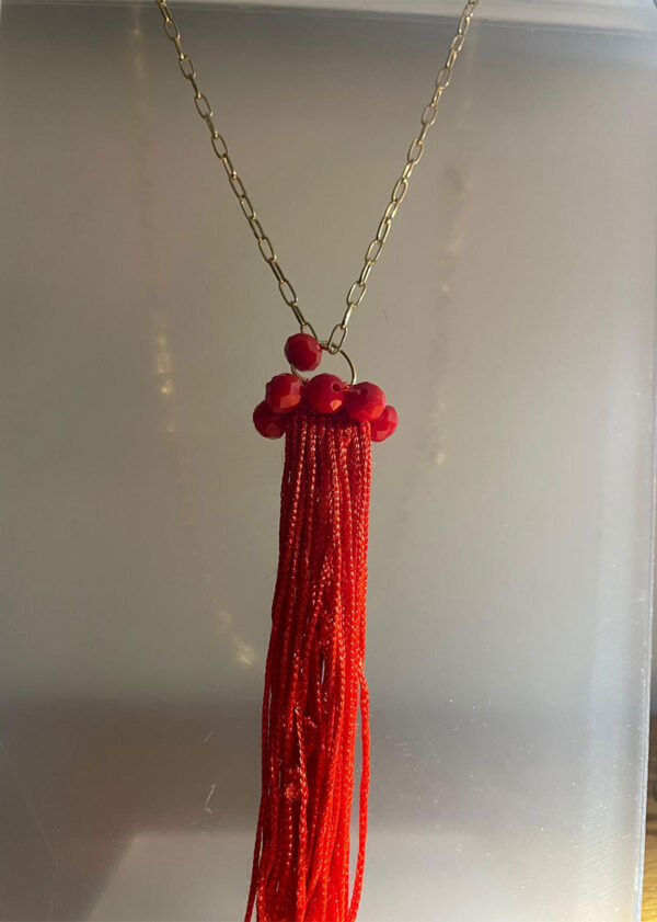 Collar largo en dorado, en fantasía y dije en hilo y piedras rojas en cristal