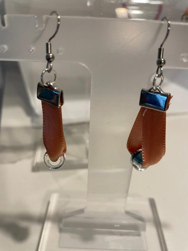 Aretes hechos en cinta color naranja y acero inoxidable